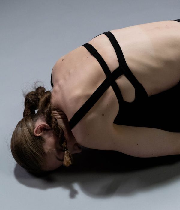 Woman in a calm yoga pose focusing on her back alignment.